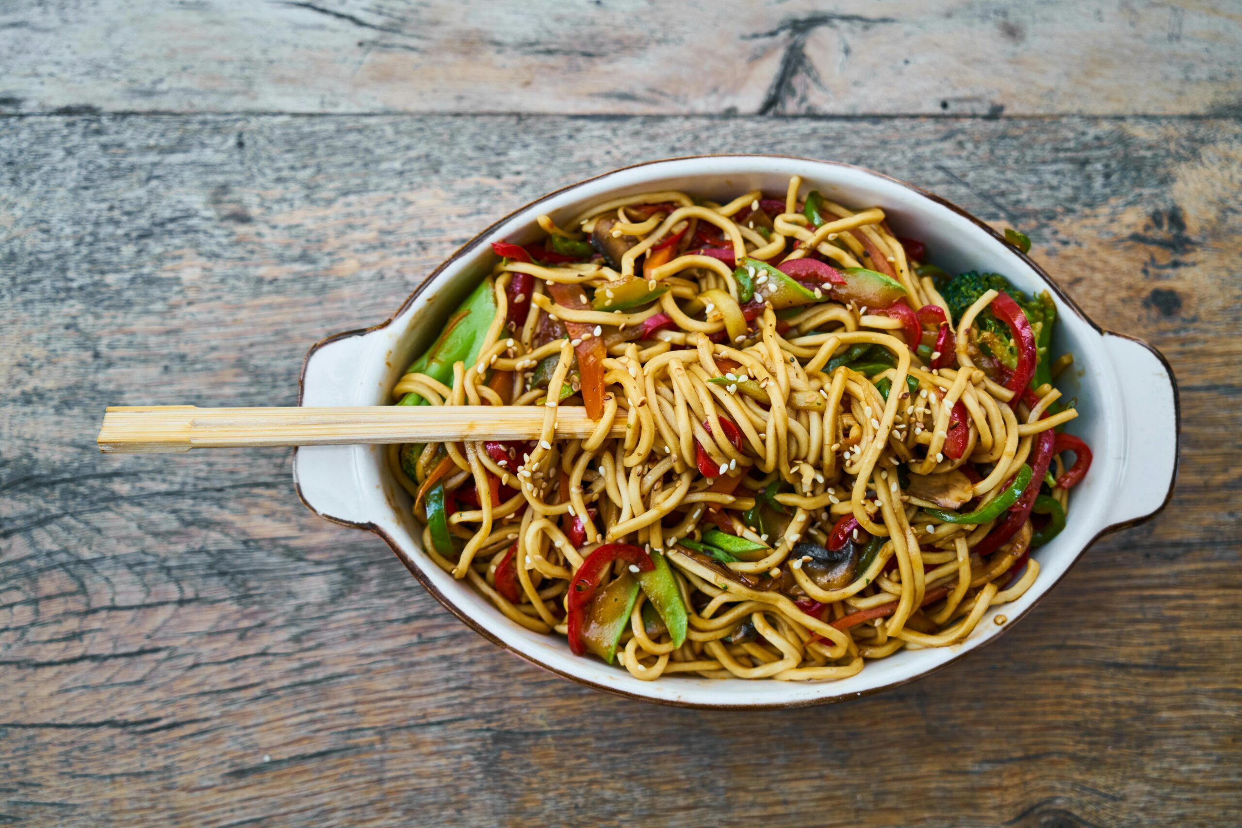 Tasty stir-fried noodles with fresh vegetables and sesame seeds, perfect for a healthy meal.